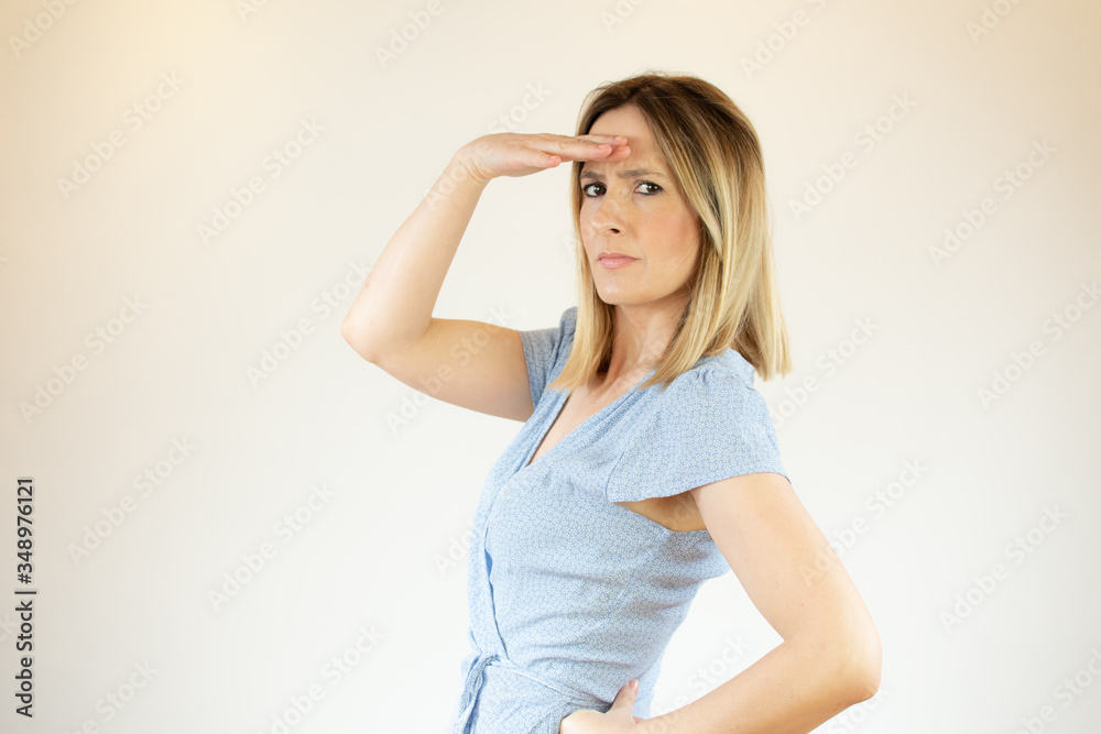 Young beautiful woman wearing blue dress and making gesture with her hand Young beautiful woman wearing blue dress and making gesture with her hand