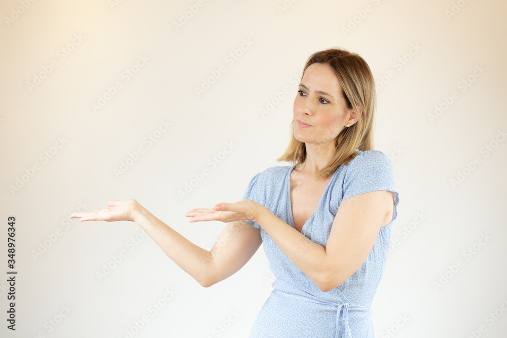 Young beautiful woman wearing blue dress showing something with her hands Young beautiful woman wearing blue dress showing something with her hands