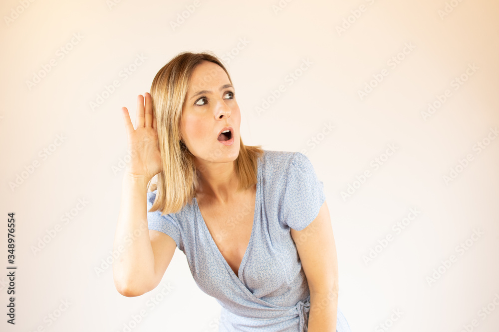 Young pretty woman wearing blue dress and making listening gesture Young pretty woman wearing blue dress and making listening gesture