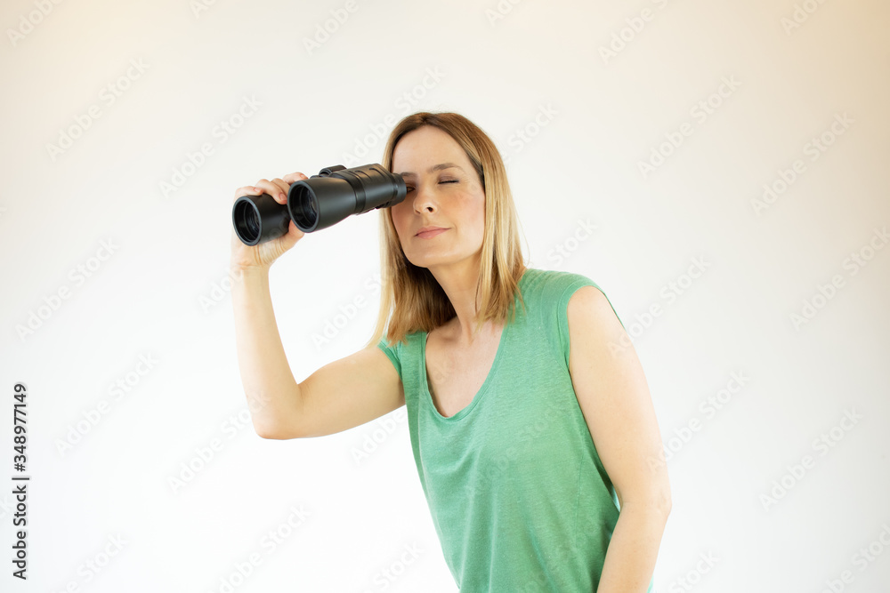 Woman in green shirt looking through binoculars