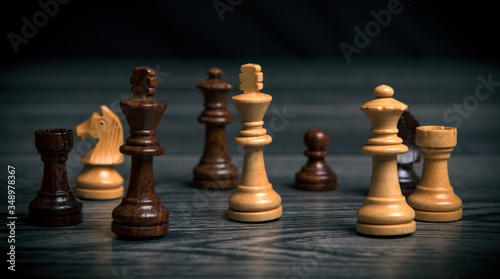 various chess pieces arranged in a row on a wooden background