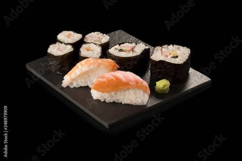 Sushi de salmón y wasabi sobre fondo negro. Salmon and wasabi sushi on black background.