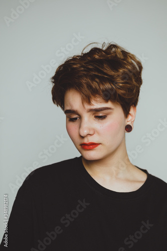 Quadro su tela Girl with short hair cries on a white background