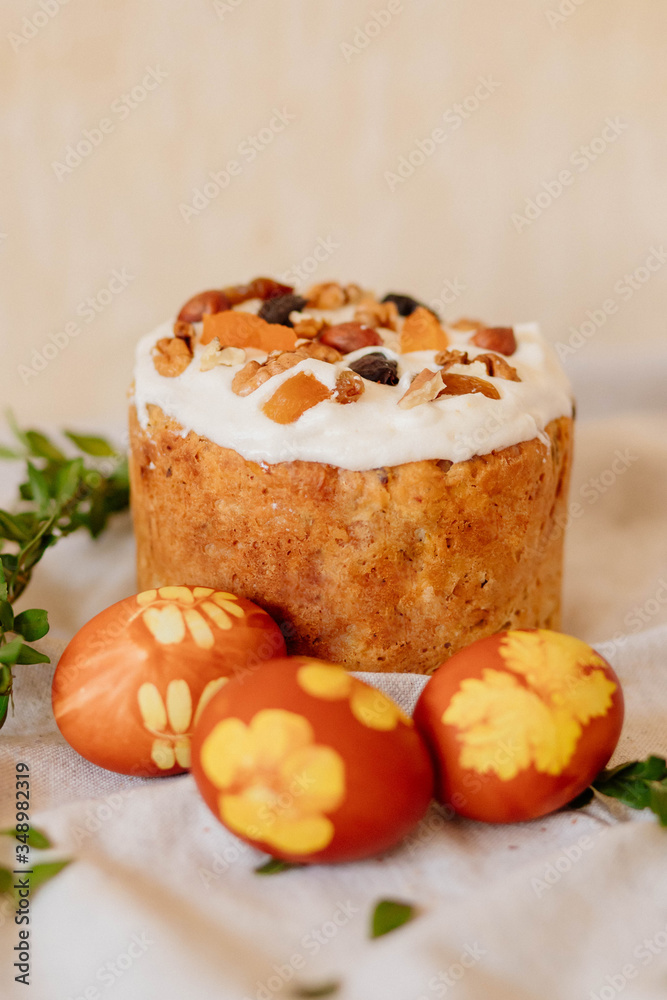 Easter cake and red eggs with twigs leaves on linen light background, easter celebration concept. Top view. Easter cake and red eggs with twigs leaves on linen light background, easter celebration concept. Top view.