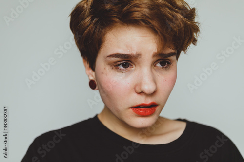 Obraz na płótnie Girl with short hair cries on a white background