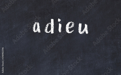 College chalk desk with the word adieu written on in