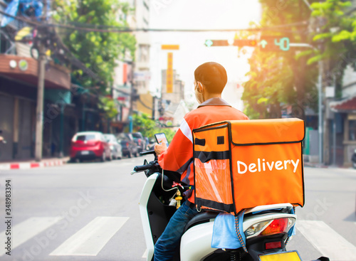 Food delivery drivers are driving to deliver products for customers who order online. The impact of the epidemic has increased online purchases.