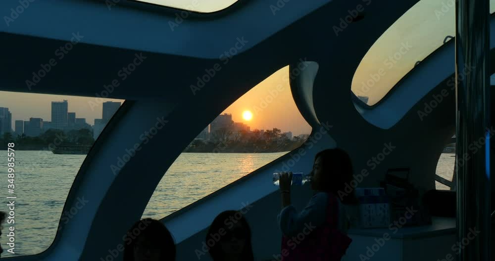 Japanese woman drinks bottled water in Odaiba's sunset, Tokyo, Japan. Futuristic boat perspective 4K Japanese woman drinks bottled water in Odaiba's sunset, Tokyo, Japan. Futuristic boat perspective 4K