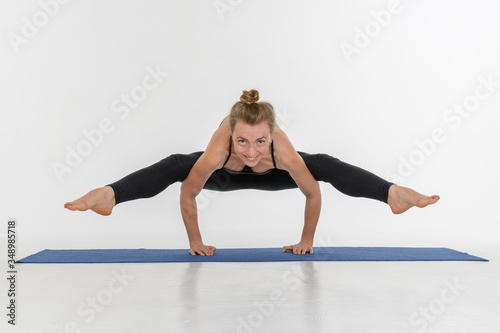 Fototapeta Naklejka Na Ścianę i Meble -  Sporty attractive young woman doing yoga practice on white background.
