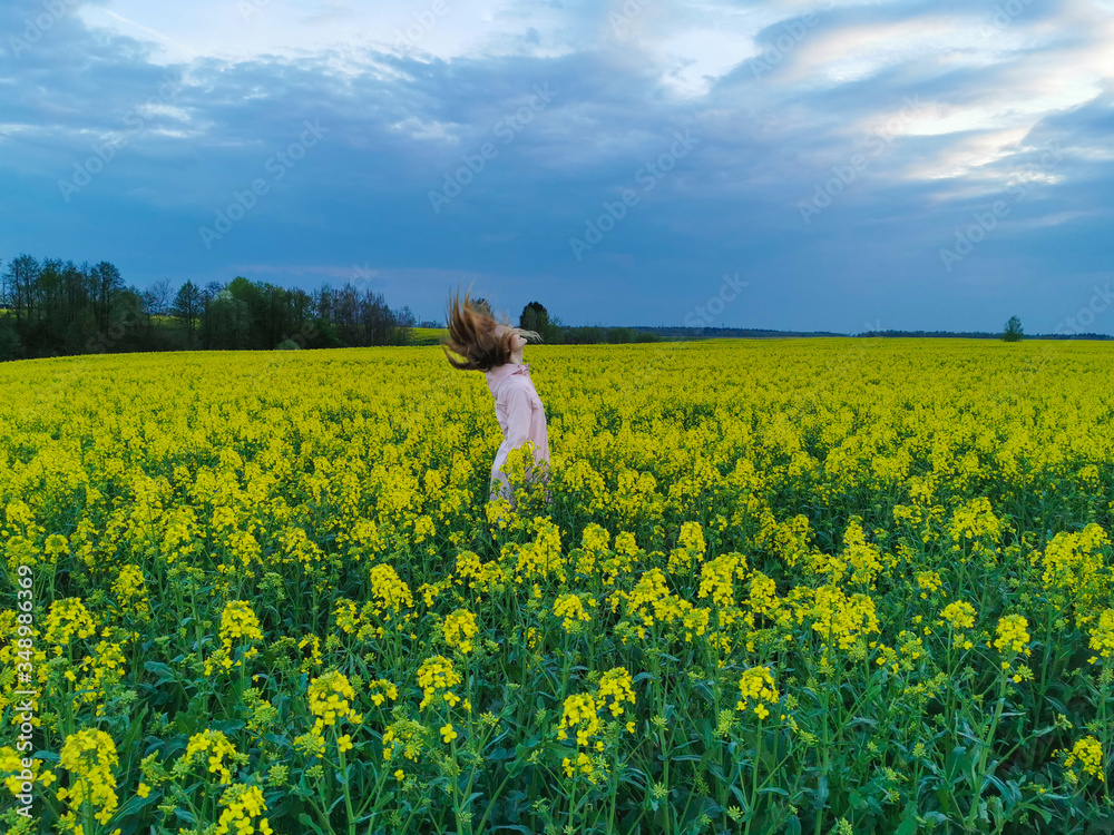 Beautiful blonde girl in a rape field before the storm. Girl and flowers. Beautiful blonde girl in a rape field before the storm. Girl and flowers.