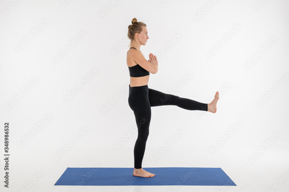 Sporty attractive young woman doing yoga practice on white background.