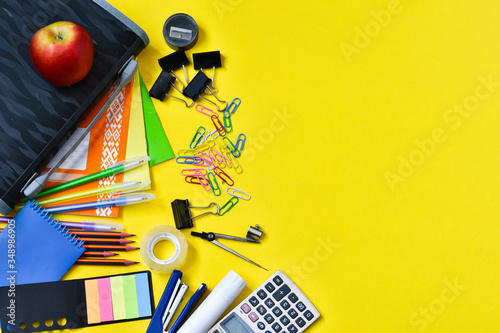 Concept back to school. Top view of colorful school supplies on a yellow background. Place for text