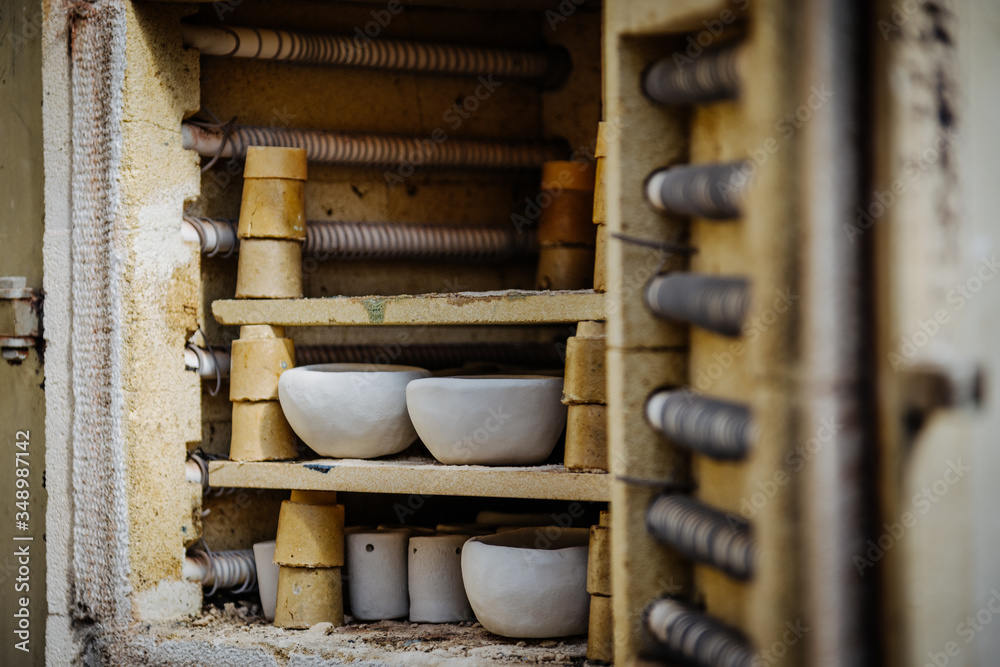 Viele rustikale Schalen aus Ton im Brennofen. Rohe Keramikprodukte ohne Glasur, Ansicht. Kunstgewerbe, Hobby und Lifestyle