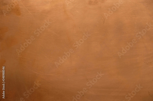 Copper surface in daylight indoors. Copper background with scratches. Copy space. Minimalism.