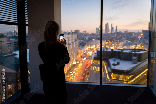 A girl shooting a panorama of Moscow at night