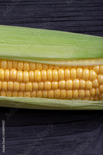 Ear of corn on a black wooden background.