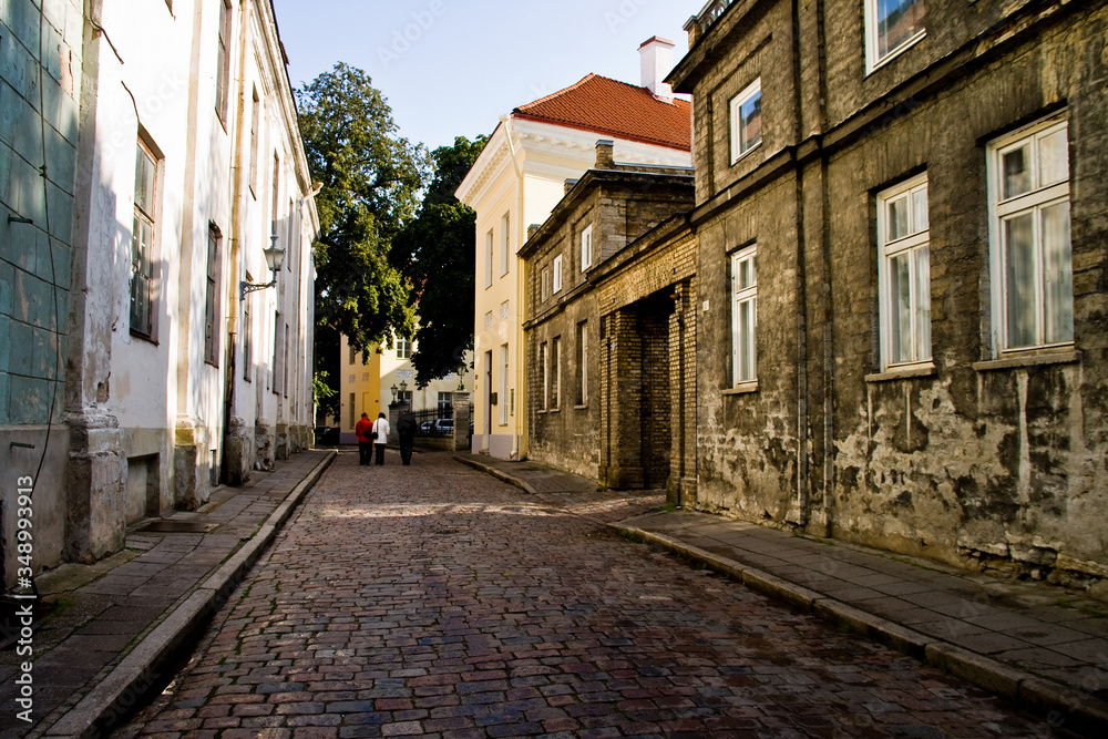 A street with houses and a cobblestone road in the center of the old city in Tallinn, Estonia