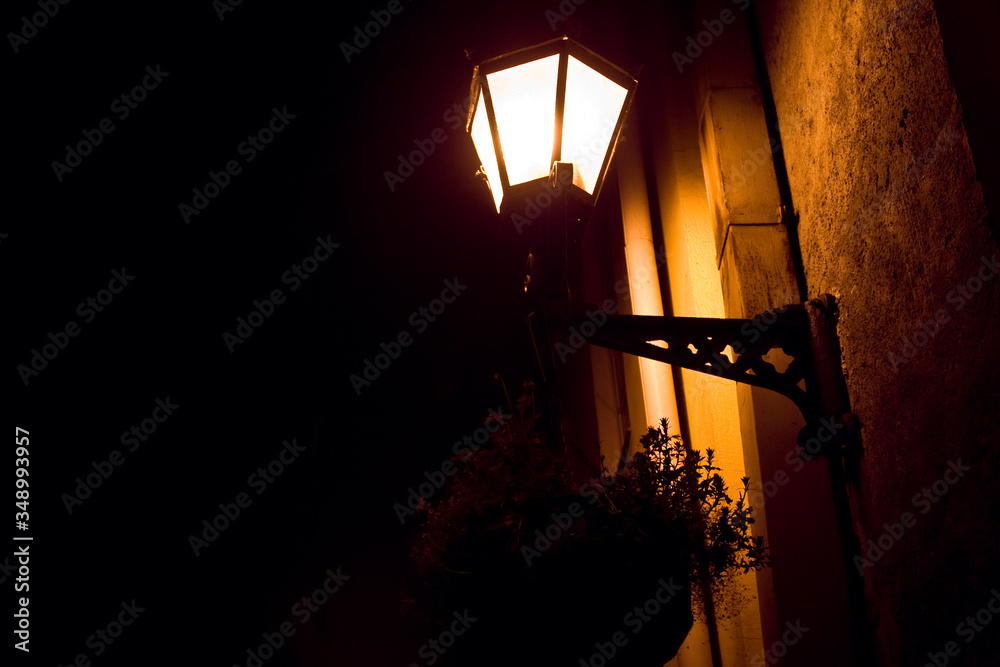 Street lamp illuminates the street of a night city in Europe