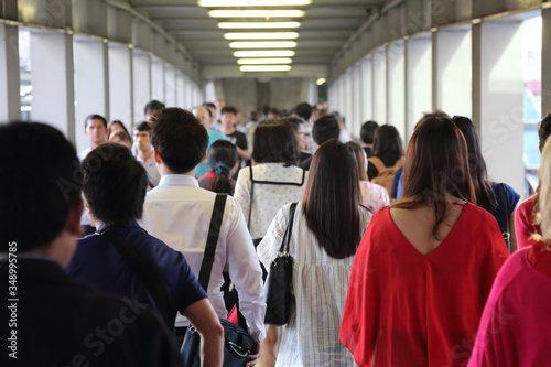 Unidentified crowded asian people walking through the path
