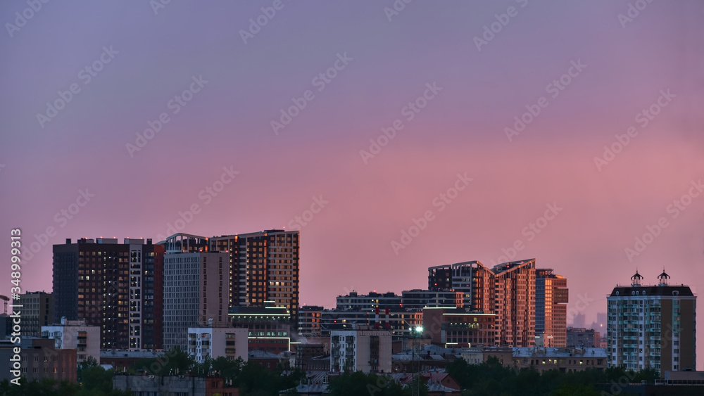 Obraz premium The city is lit by the setting sun. City landscape.