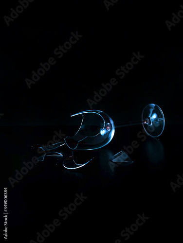 Broken wine glass blue black background closeup copy space