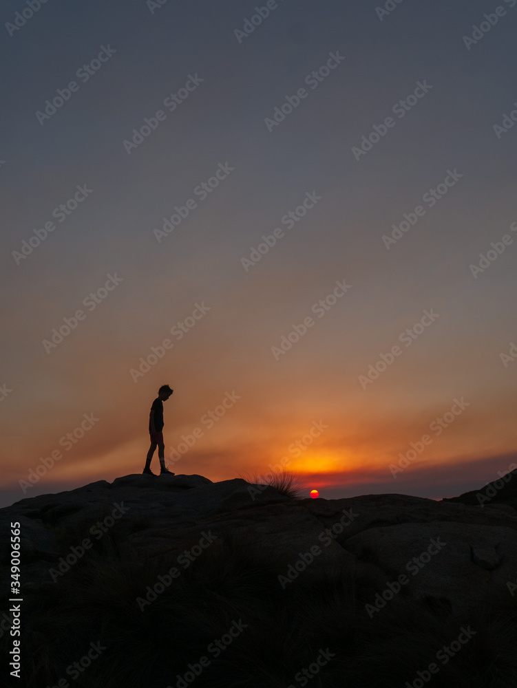 silhouette of man standing on top of mountain sunset