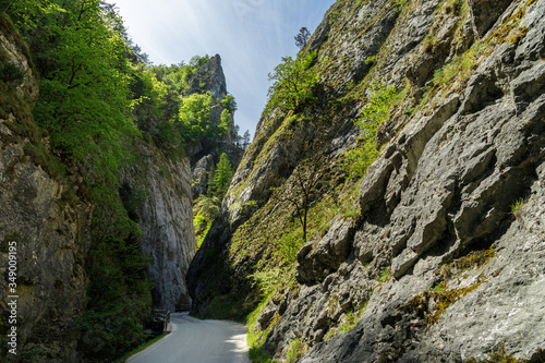 Curvy road between steep rocks of Maninska tiesnava gorge in Strazovske vrchy mountains, Slovakia. Sunny spring day. photo