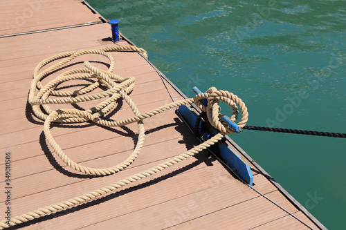 Mooring lines are wound on the bollards, bitengs, on the pier, the ships in the Marina are safe. The concept of safe navigation. © Irina