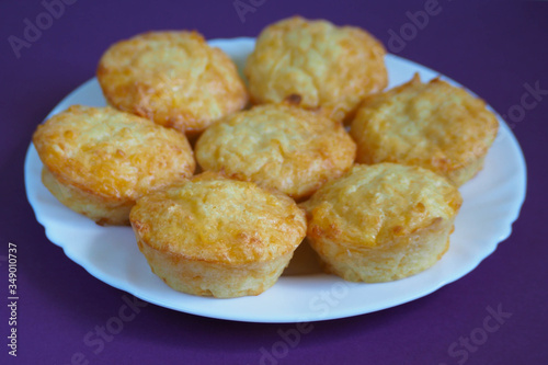 seven cheese muffins from cottage cheese, eggs and rice flour on a white round plate on a lilac background.  gluten free food cooked at home.  bakery products