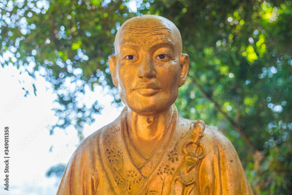 Beautiful unique buddha statue close shot, looking at the camera. Golden sculpture representing buddhist/monk. Ten Thousand Buddhas Monastery, Sha Tin, Hong Kong. Peaceful sunlight. Beautiful unique buddha statue close shot, looking at the camera. Golden sculpture representing buddhist/monk. Ten Thousand Buddhas Monastery, Sha Tin, Hong Kong. Peaceful sunlight.