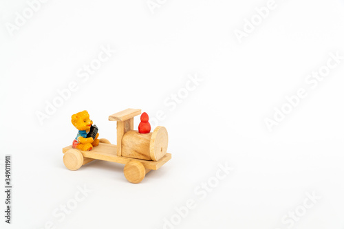 Obraz na płótnie Wooden train on a white background. Wooden toy yellow locomotive with a teddy bear. w salonie