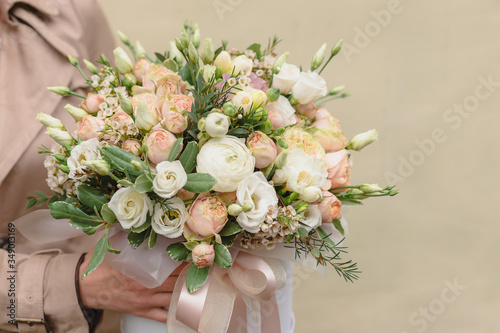 A large flower arrangement in a big white hat box was created by a florist for a wedding gift. White Freesia    Ranunculus asiaticus  eustoma flowers  roses and eucalyptus in a flowers box