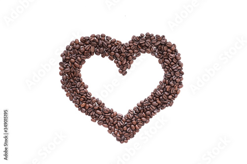 Heart laid out from coffee beans on a white background.