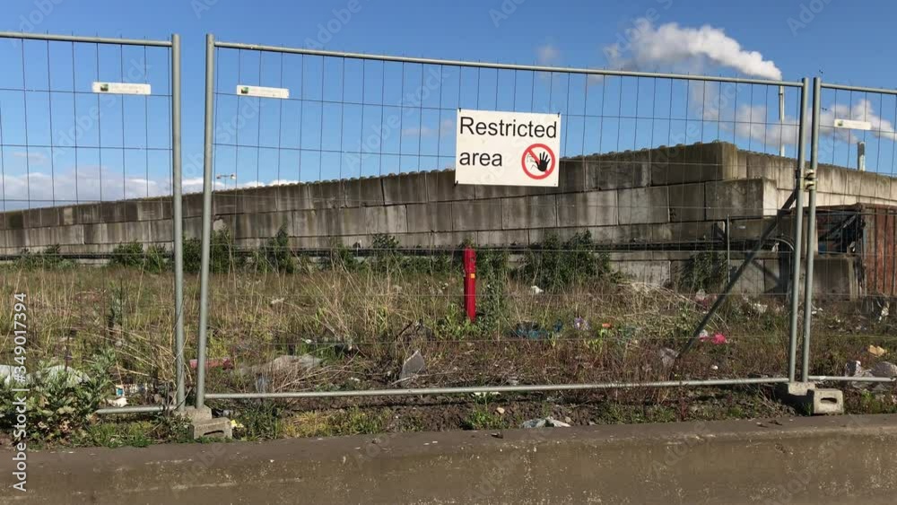 Restricted area sign on a Fence. Fire hydrant on industrial wasteland. Restricted area sign on a Fence. Fire hydrant on industrial wasteland.