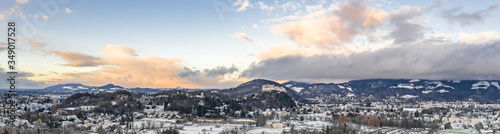 Panoramic aerial drone view of Salzburg mountain and snowy outskirt with view of Hohensalzburg fortress during sunset time © Davidzfr