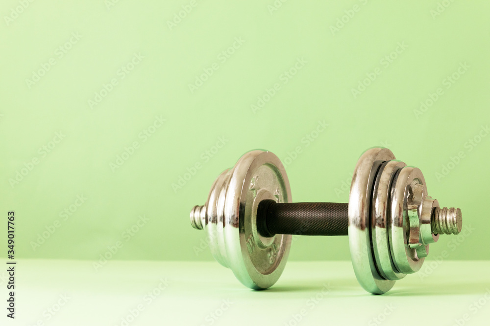 Dumbbell on a green background. Fitness healthy and sport concept Dumbbell on a green background. Fitness healthy and sport concept