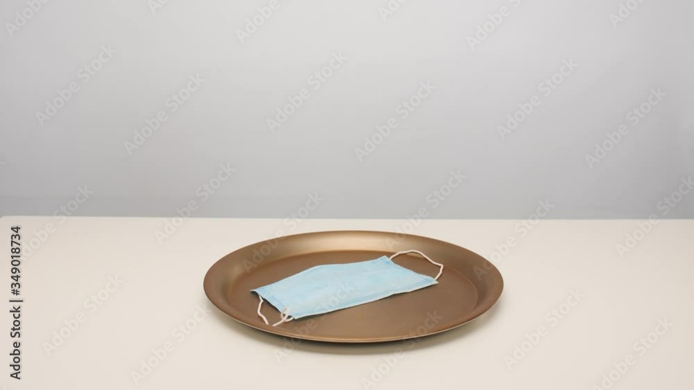 Male waiter opening tray with medical protective mask on white table Male waiter opening tray with medical protective mask on white table