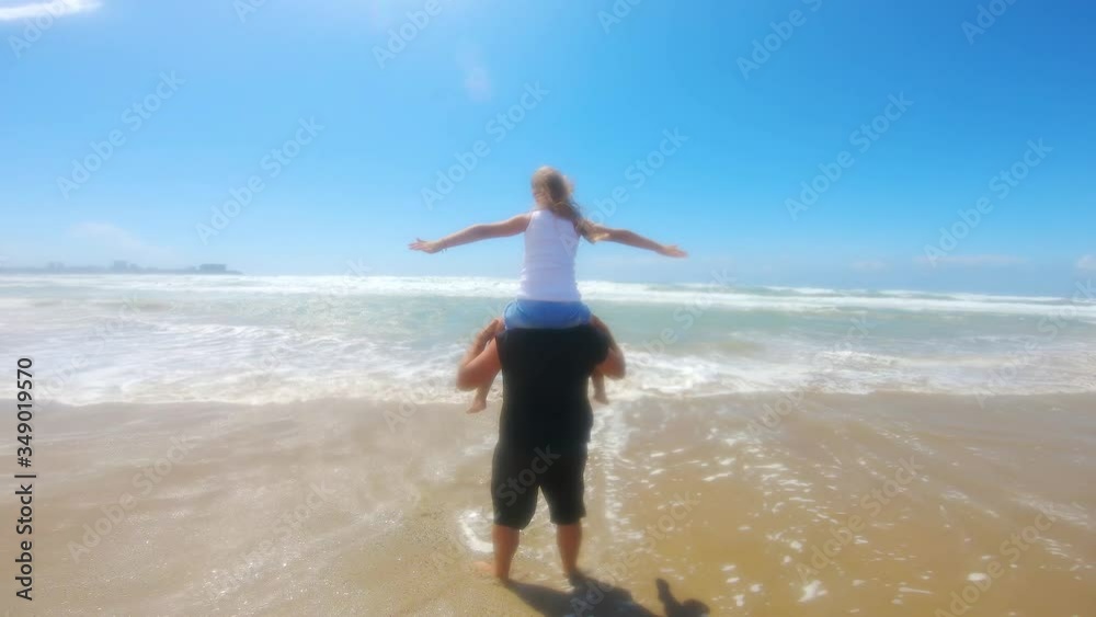 Happy father and daughter play on the beach during a sea storm. Concept of friendly family, travel, lifestyle. Happy father and daughter play on the beach during a sea storm. Concept of friendly family, travel, lifestyle.