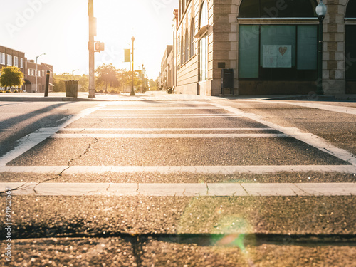 Fototapeta Naklejka Na Ścianę i Meble -  Empty downtown street, crosswalk, small, town, sunrise, solar flare, 