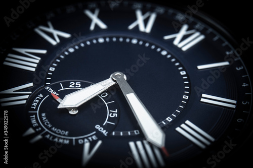 Watch face close-up. Low-key macro picture taken in studio. Concept image concerning time and planning activity.