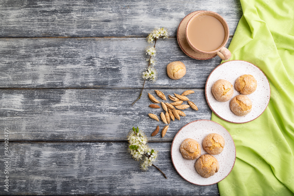 Almond cookies and a cup of coffee on a gray wooden background. Top view, copy space. Almond cookies and a cup of coffee on a gray wooden background. Top view, copy space.