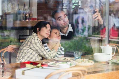 A happy family taking a selfie inside the cafe