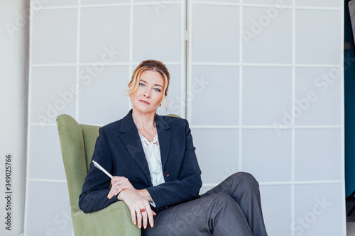 beautiful business woman psychologist sits in green chair