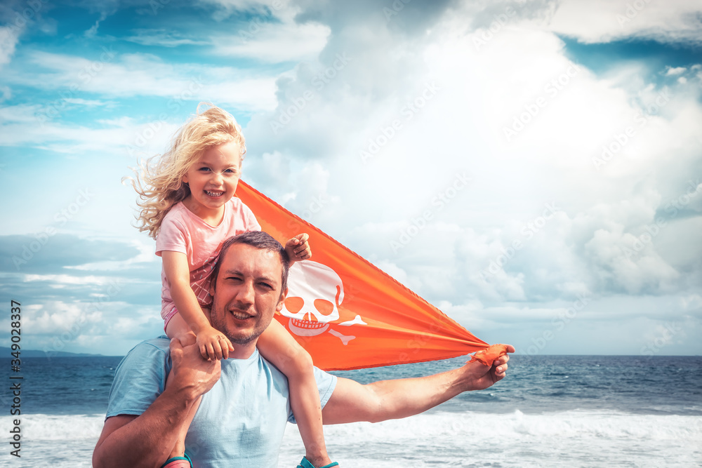 Obraz premium Happy family father and child daughter on his shoulders against blue sky and sea 