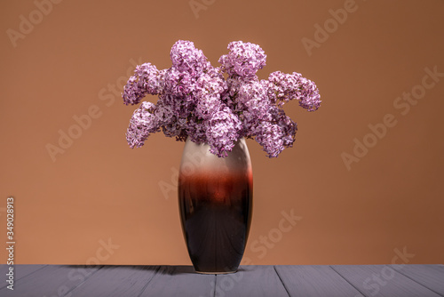 Bouquet Of Spring Purple Lilac In A Vase on a grey wooden table