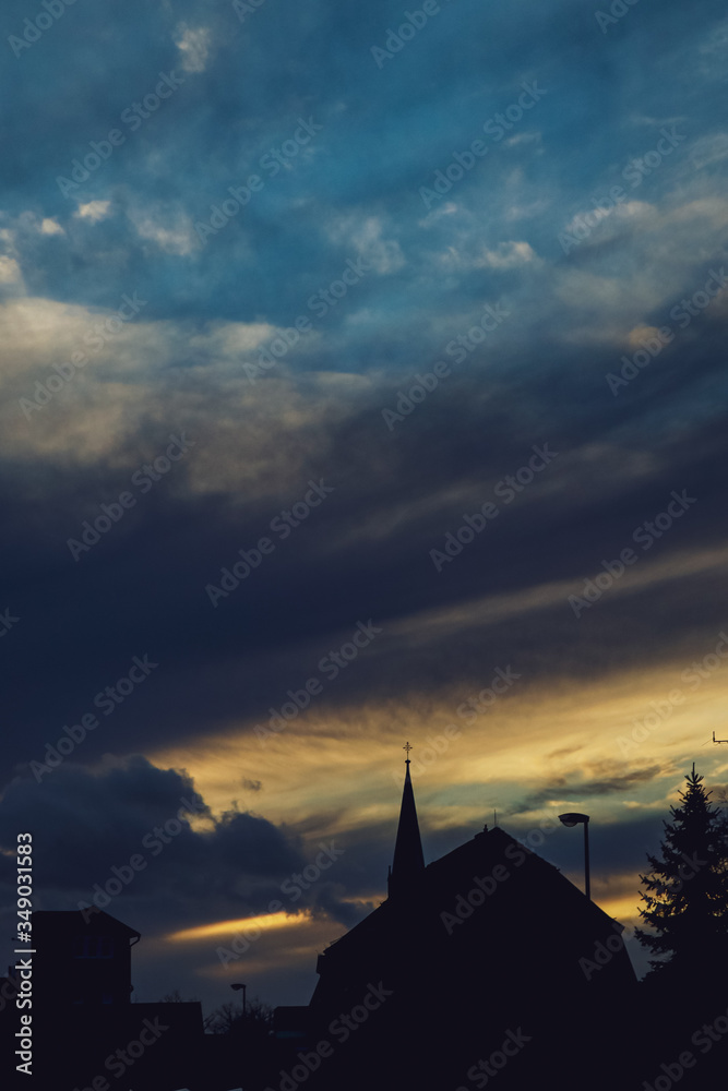 beauty sunset, blue and yellow sky and dark clouds building and tree in sunset use for sunrise or sunset background. place for text