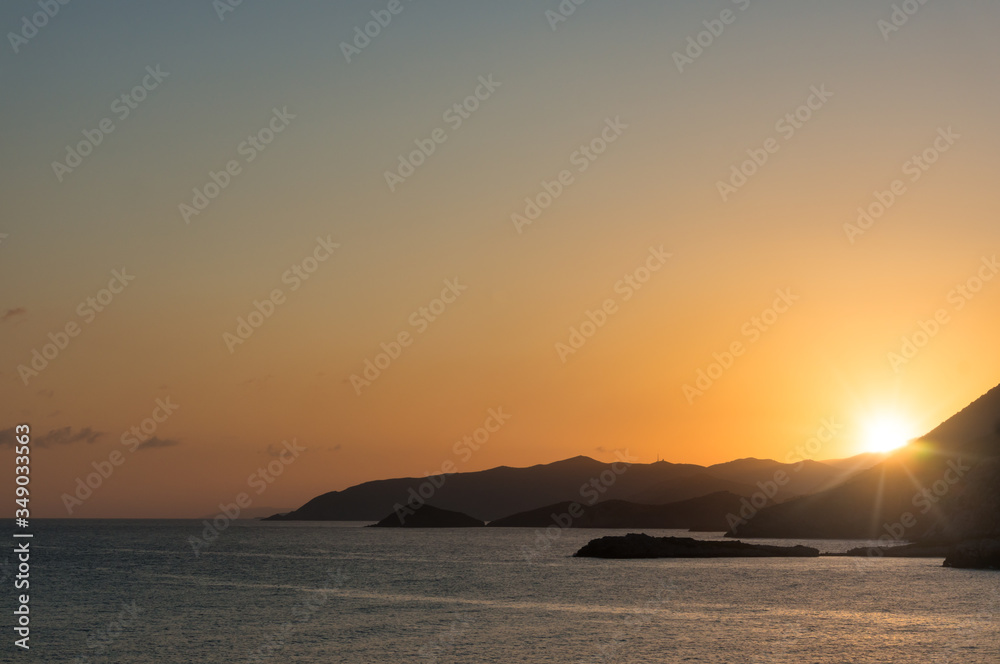 Magnificent sunset over the sea and mountains. Travel invitation.