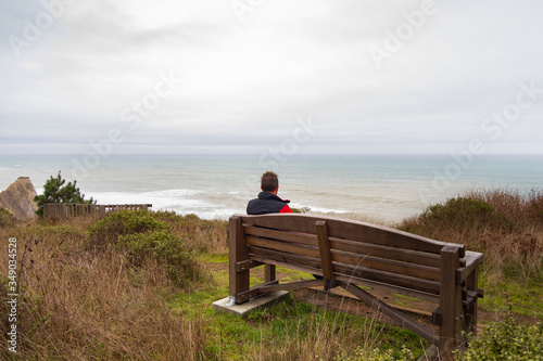 Hiker man resting on bench at the beach © Martina