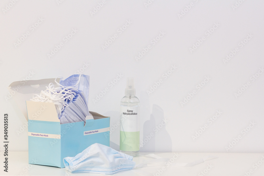 A box of disposable face masks and a bottle of disinfectant spray to protect from the covid19
