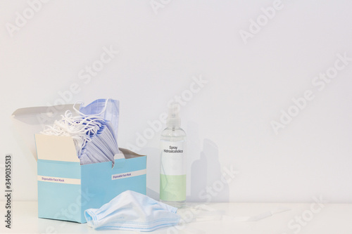 Obraz na płótnie A box of disposable face masks and a bottle of disinfectant spray to protect from the covid19 w salonie